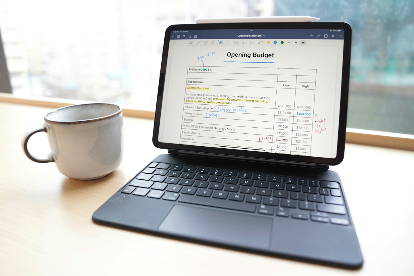 Masanın üzerinde notların olduğu bütçe belgesini gösteren tablet.